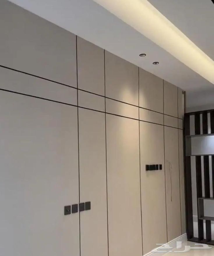 Grand mur panneauté beige avec fins joints et spots encastrés — بديل الشيبورد NovaBard Tanger